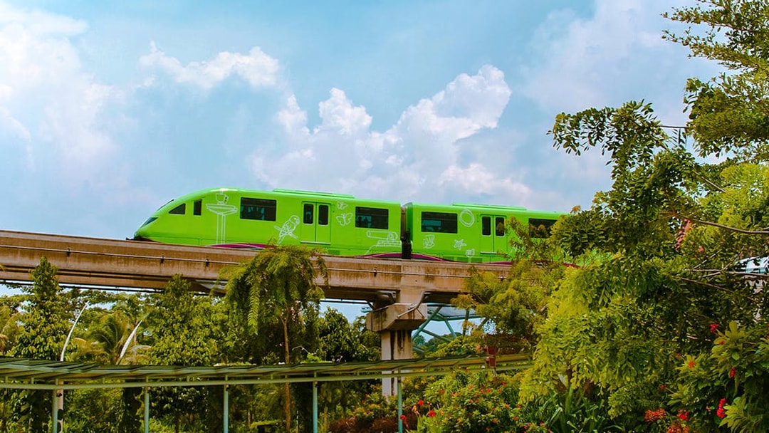 Sentosa Monorail Express traveling through lush greenery in Singapore.