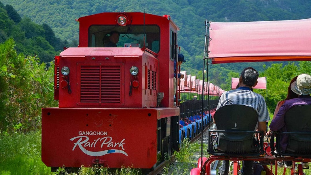 Gangchon Rail Park ride with passengers on a rail bike, surrounded by lush greenery in Gapyeong.