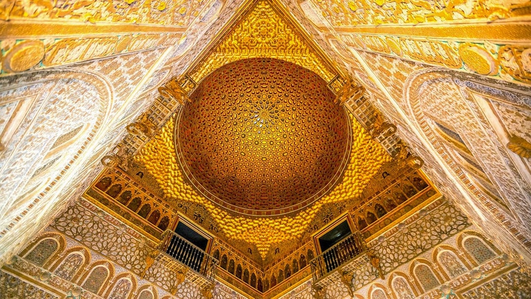 Intricate ceiling of the Alcazar of Seville with detailed geometric patterns.