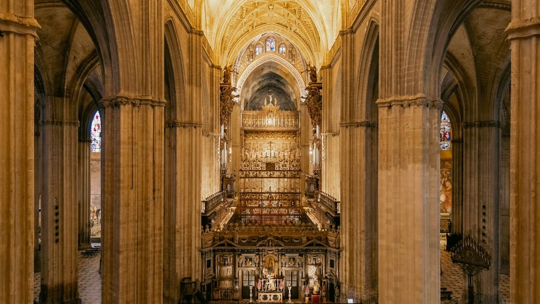 Seville Cathedral interior with ornate altar and vaulted ceilings.