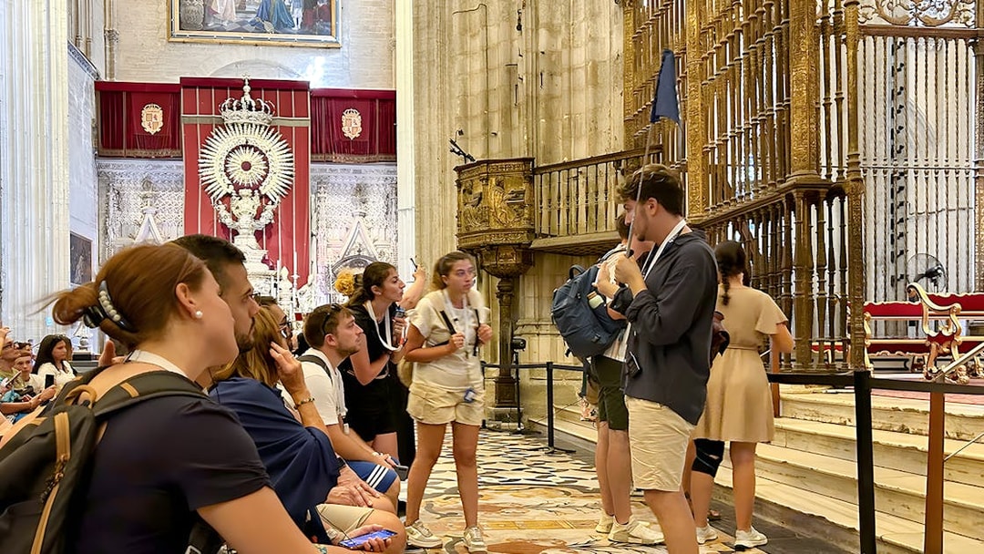 Tour group listening to a guide inside Seville Cathedral.