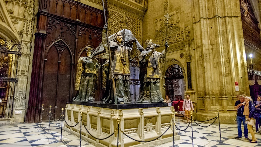 Tomb of Columbus at Seville Cathedral, featuring ornate statues and Gothic architecture.