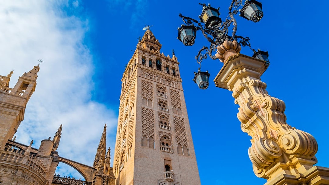 Giralda tower and ornate lamp post at Seville Cathedral, Spain.