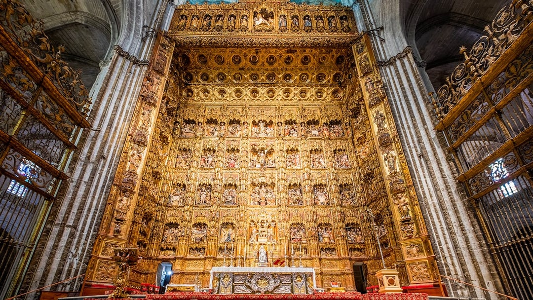 Altar of Seville Cathedral with intricate gold detailing on a guided tour.