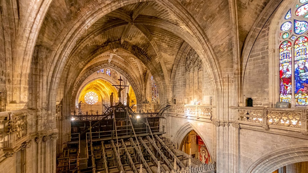 Interior view of Gothic Cathedral from balcony, showcasing vaulted ceilings and stained glass windows.