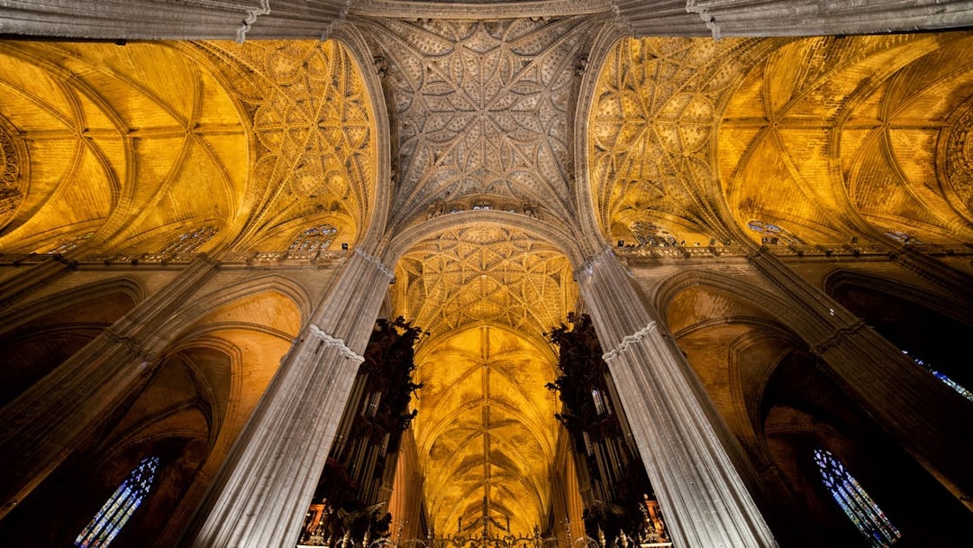 Seville Cathedral interior with ornate Gothic ceiling and columns.