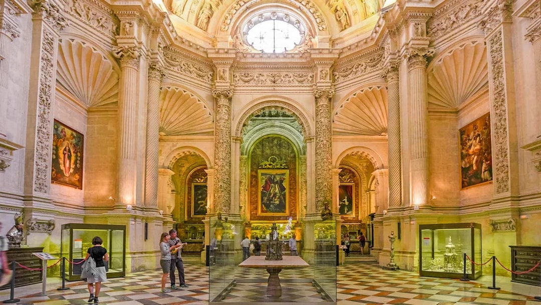 Royal chapel interior with ornate columns and religious paintings, Seville Cathedral, Spain.