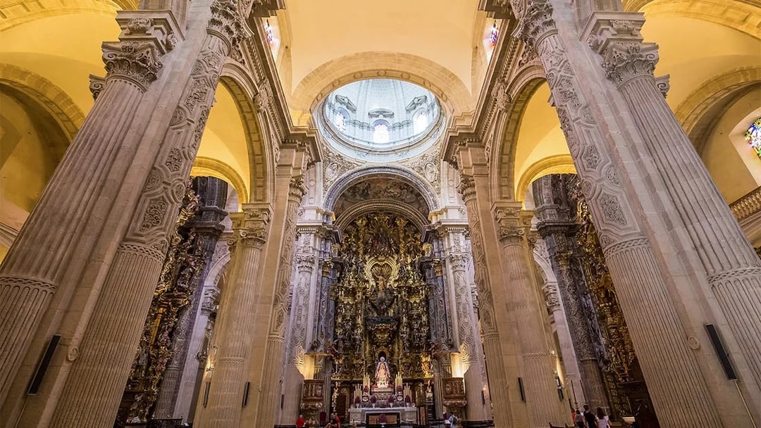 Seville Cathedral interior with ornate altar and towering columns.