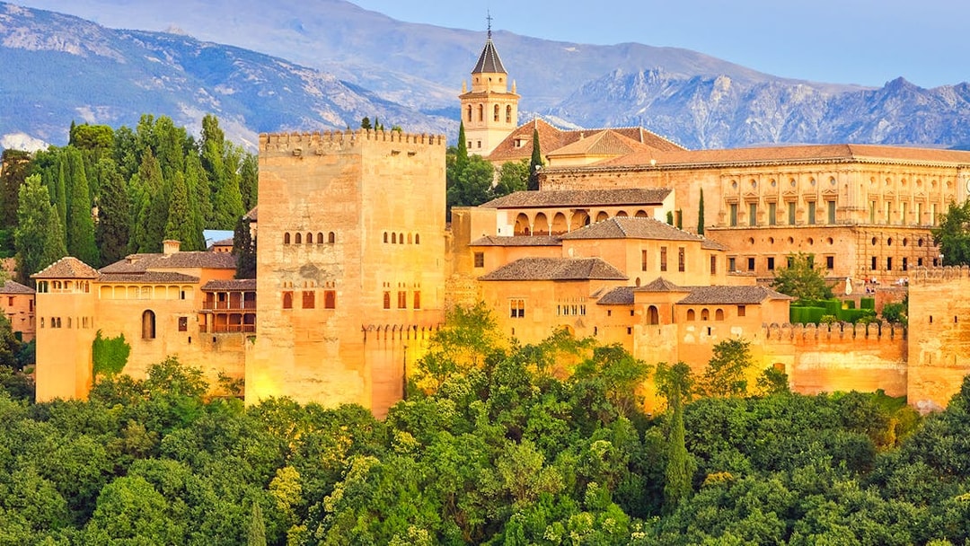 Alhambra palace complex in Granada with Sierra Nevada mountains in the background.
