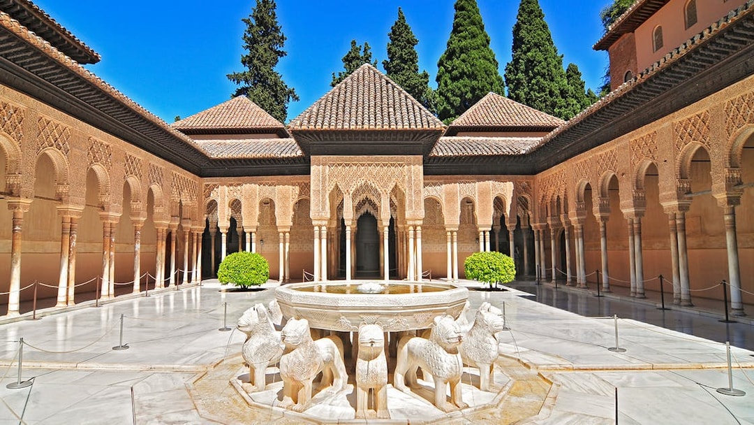 Courtyard of the Lions at the Alhambra in Granada, featuring ornate arches and lion fountain.
