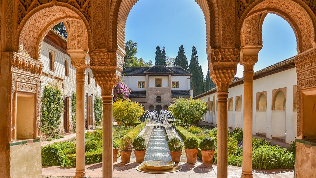 Alhambra courtyard with arches and fountain, Granada day trip from Seville.