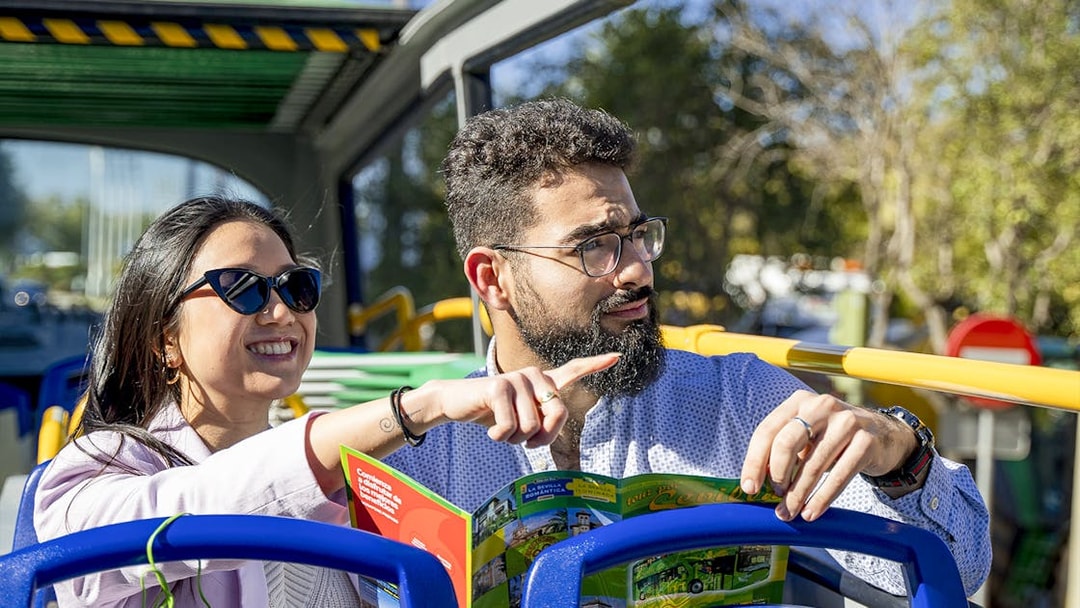 Couple enjoying Seville sights on Sevirama hop-on hop-off bus tour.