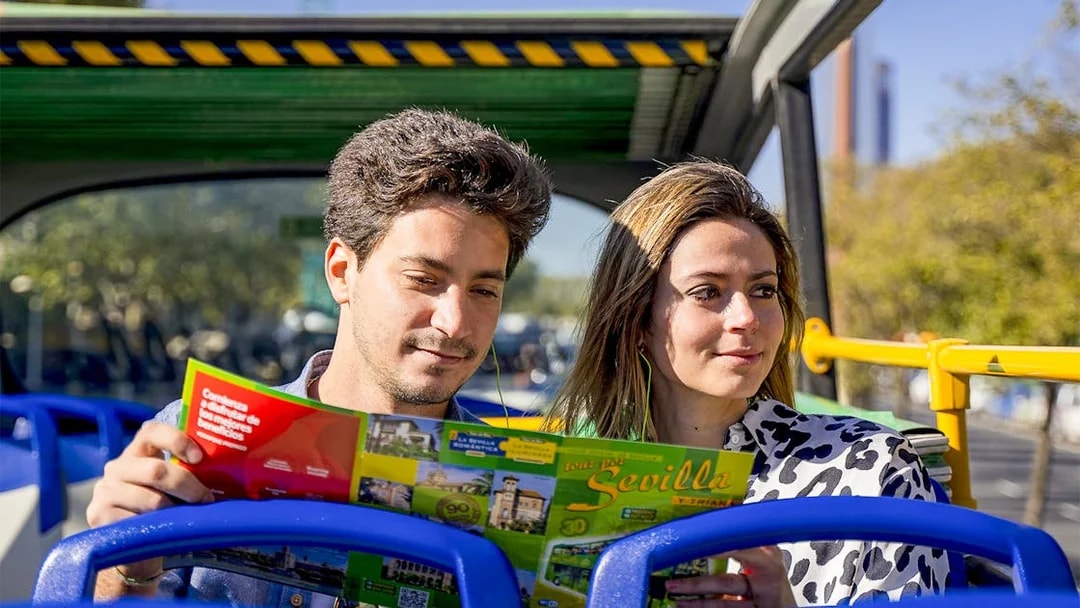 Tourists reading a map on Seville hop-on hop-off bus tour.