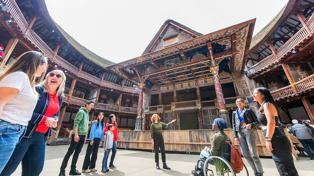 Visitors enjoying a guided tour at Shakespeare's Globe Theatre in London.