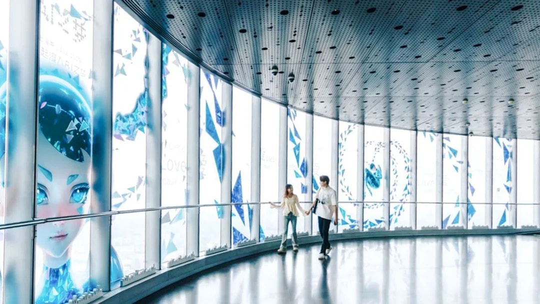 Visitors walking inside Shanghai Tower observation deck with digital art displays.