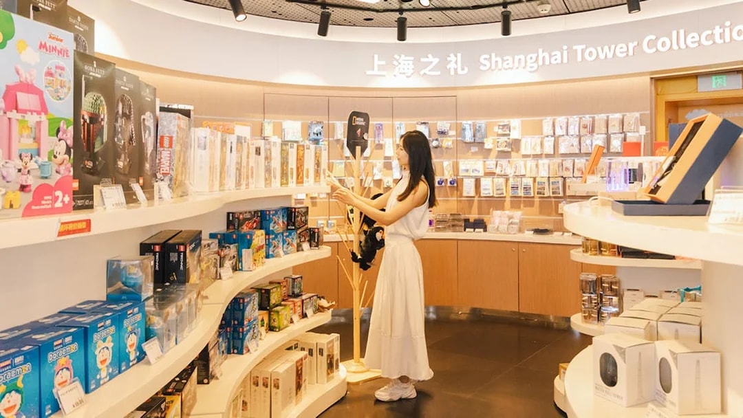 Woman browsing merchandise at Shanghai Tower Collection gift shop.
