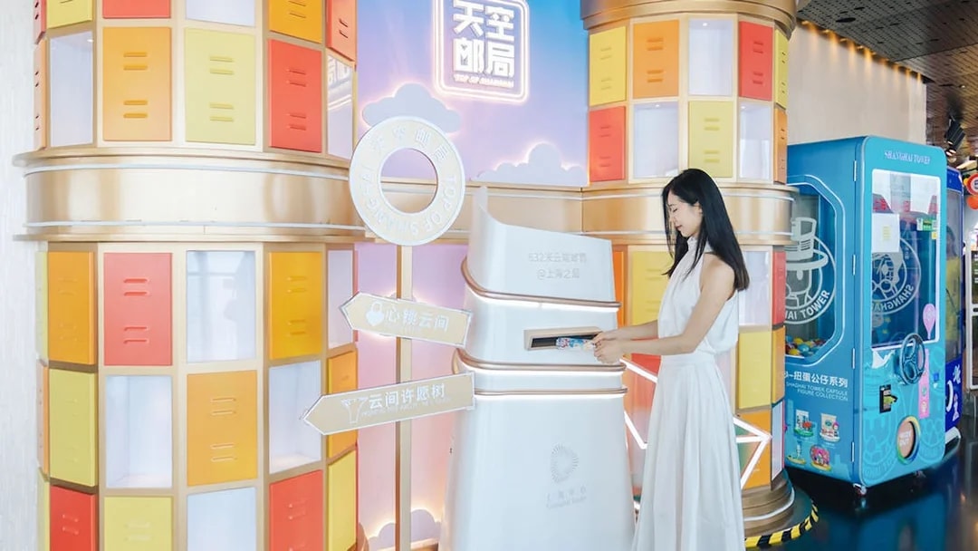 Woman interacting with a colorful display at Shanghai Tower's observation deck.