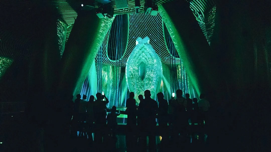 Silhouetted visitors inside Shanghai Tower's illuminated exhibit.