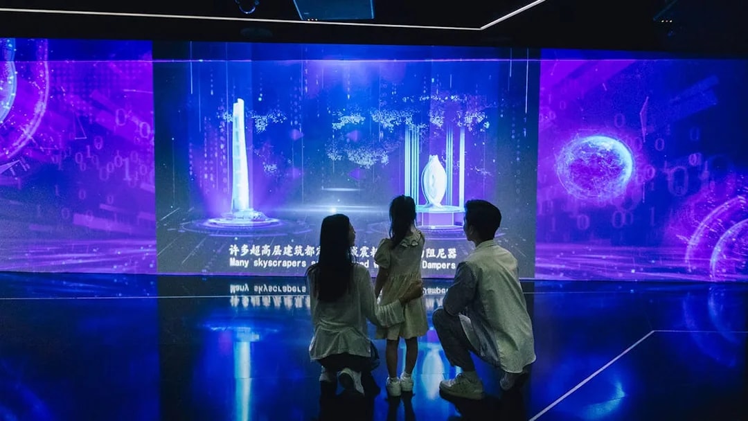 Family exploring digital skyscraper exhibit inside Shanghai Tower.