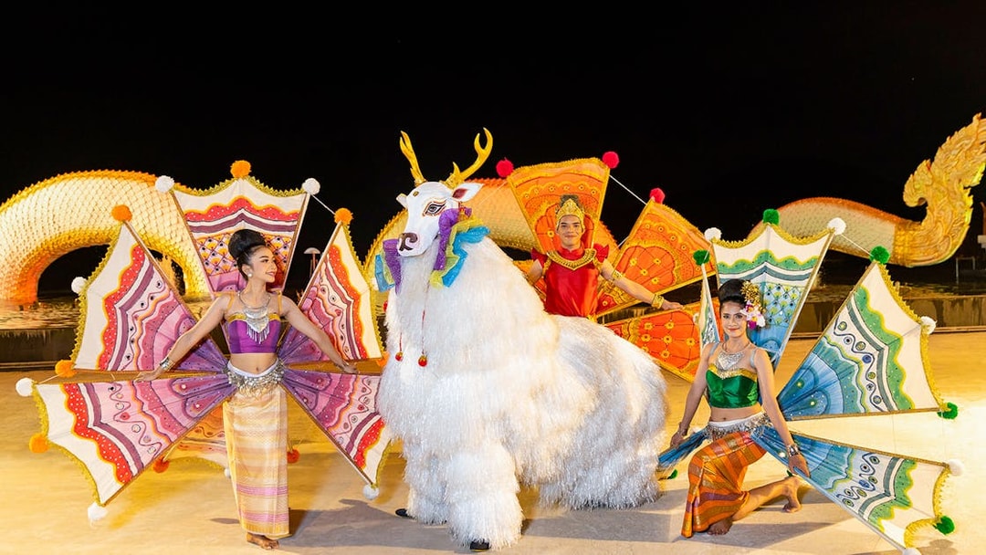 Performers in colorful costumes at Siam Niramit preshow with mythical creature.
