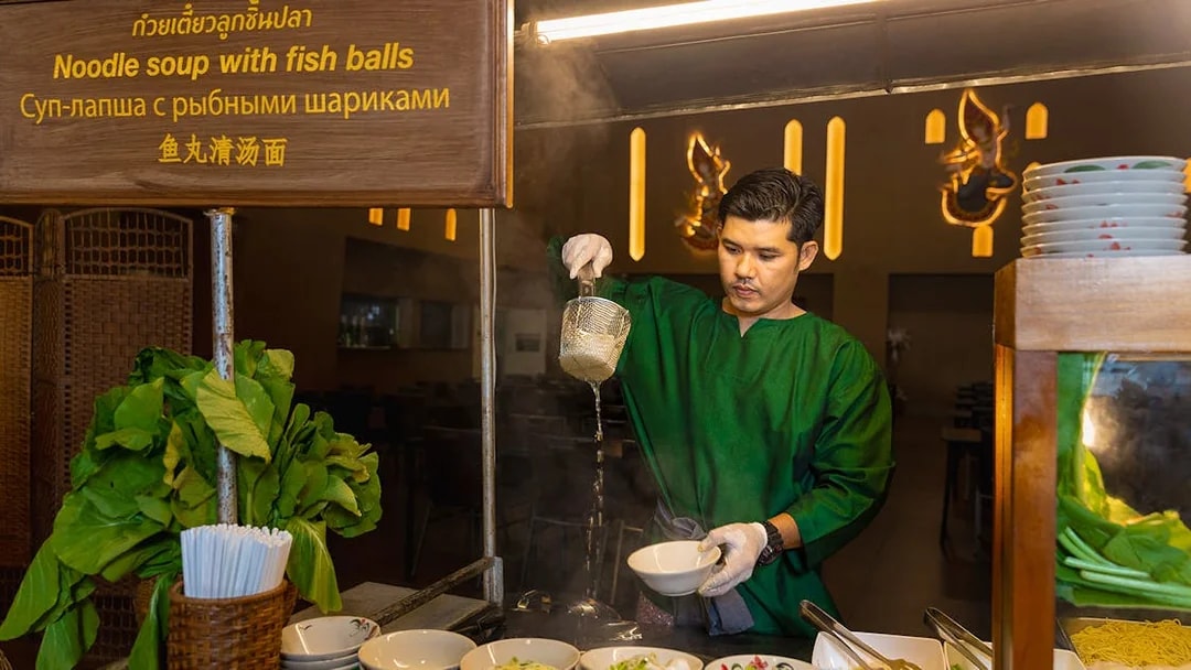Vendor preparing noodle soup at Siam Niramit buffet.
