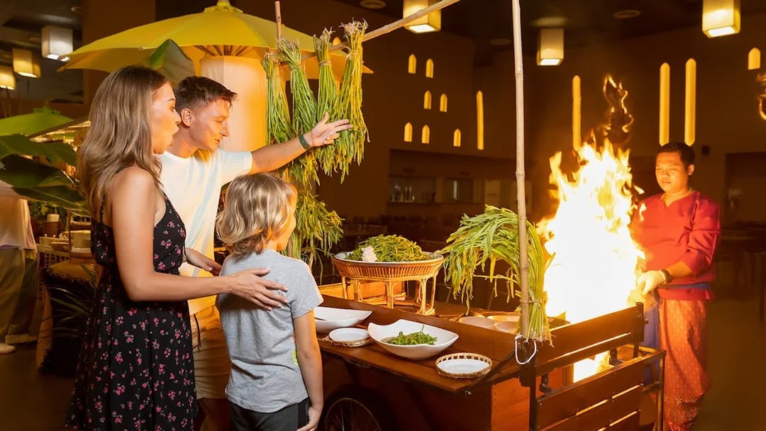 Family enjoying buffet dinner at Siam Niramit with live cooking station.