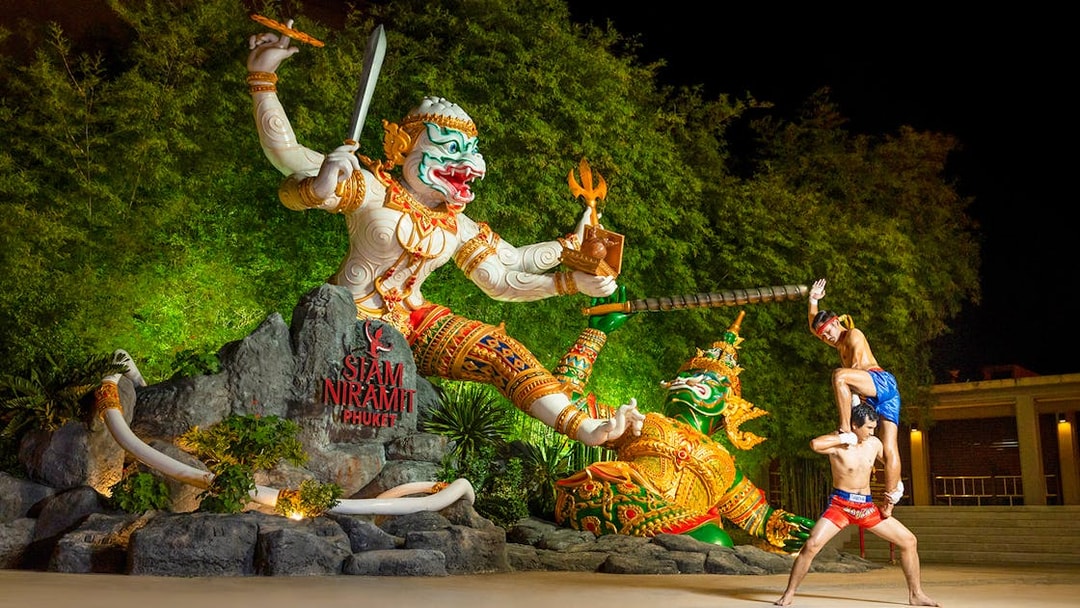 Thai boxers performing at Siam Niramit preshow in front of giant statues.