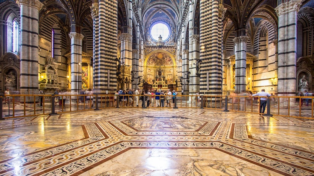 Siena Cathedral interior with striped columns and ornate marble floor, Italy.