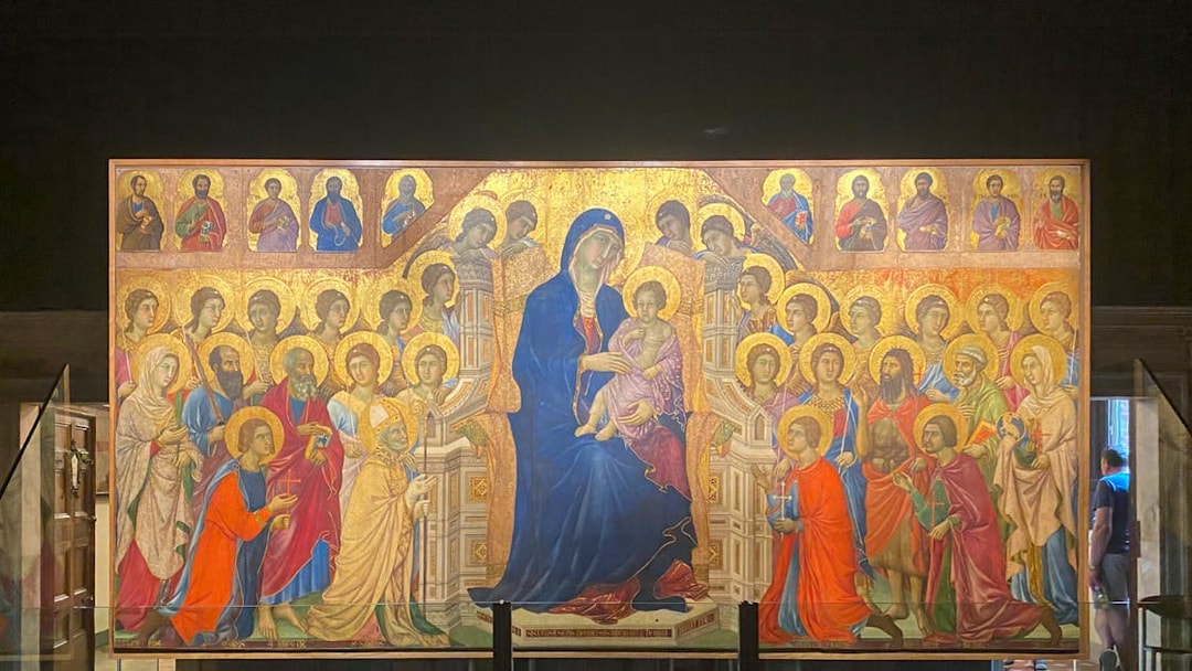 Alt text: "Tourists viewing the Maestà by Duccio at the Siena Duomo Complex in Siena, Italy.
