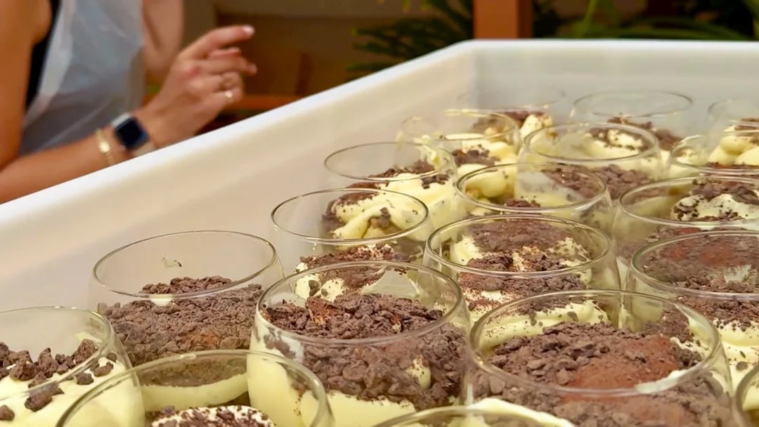 Tiramisu preparation at a cooking class in Siena with chocolate shavings.