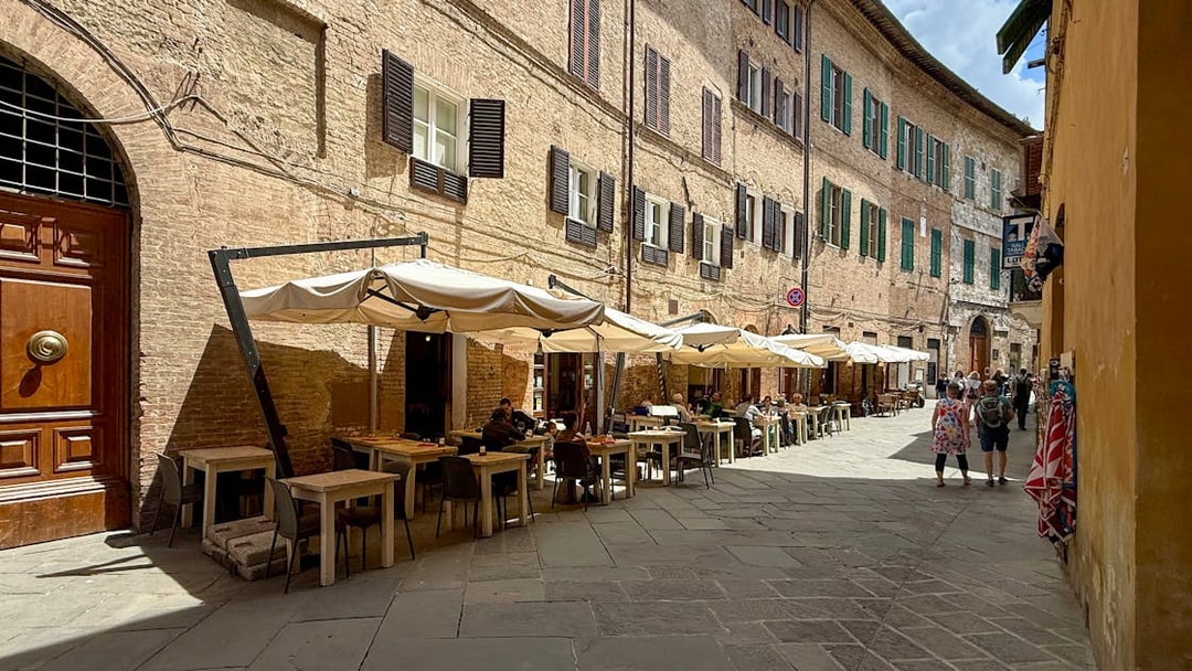 Outdoor seating at a cafe in Siena, Italy, ideal for pasta cooking classes.