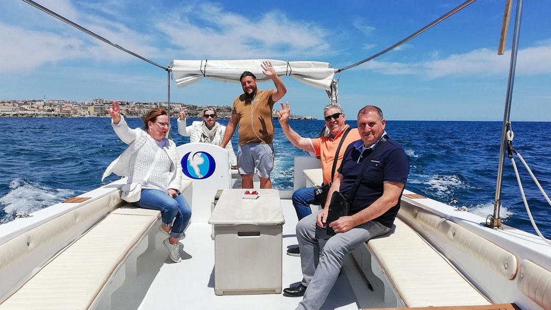 Group enjoying a boat tour to Ortigia Island and sea caves.