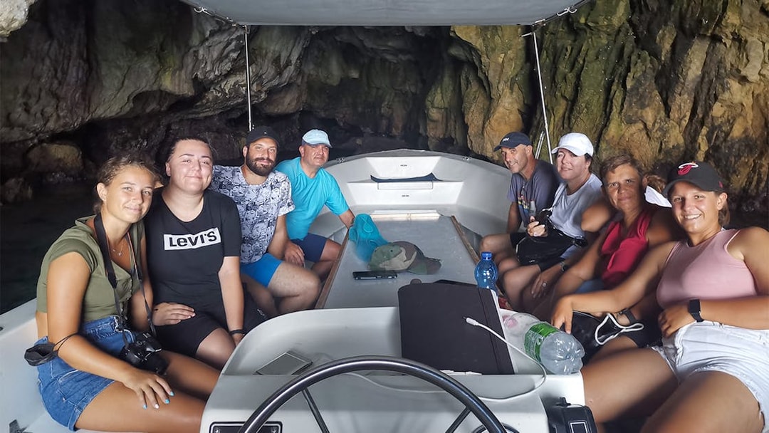 Group on a boat tour inside a sea cave near Ortigia Island.