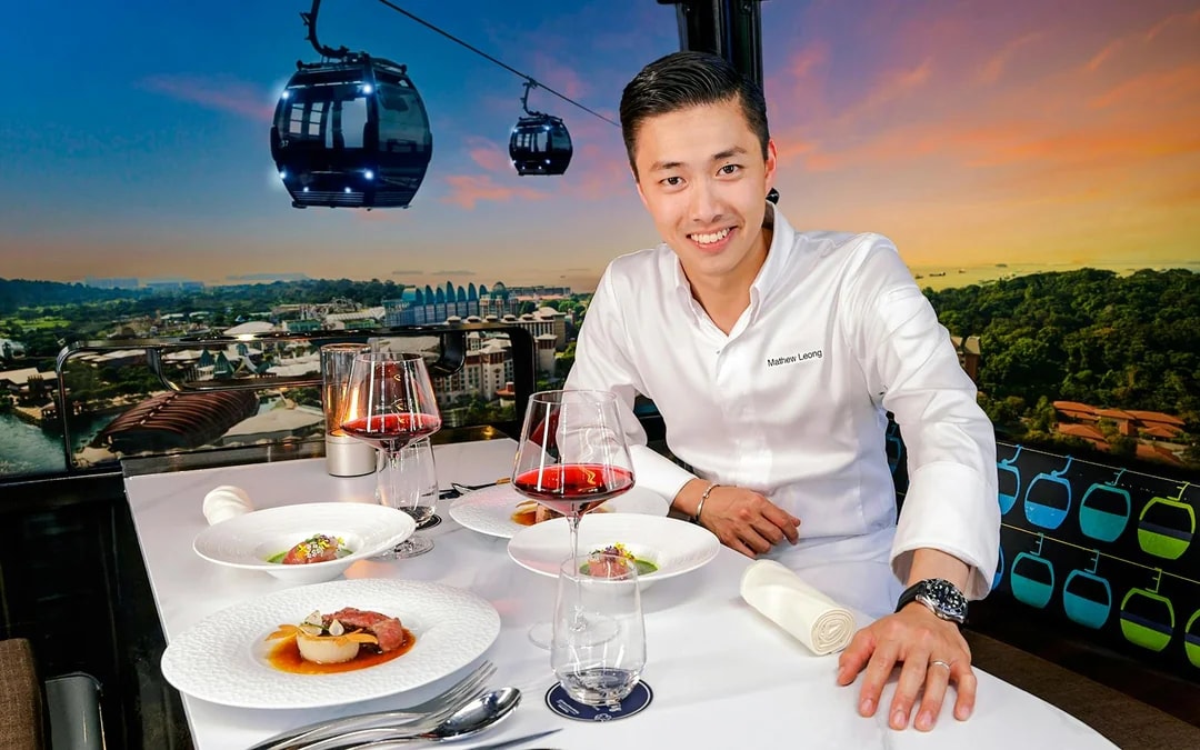 Singapore cable car dining with dishes by Chef Mathew Leong, overlooking city skyline.