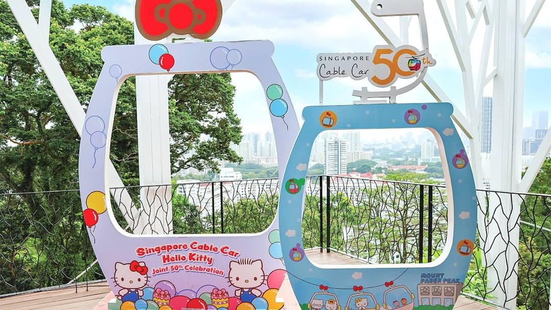 Singapore Cable Car Hello Kitty 50th celebration frame with city skyline in background.