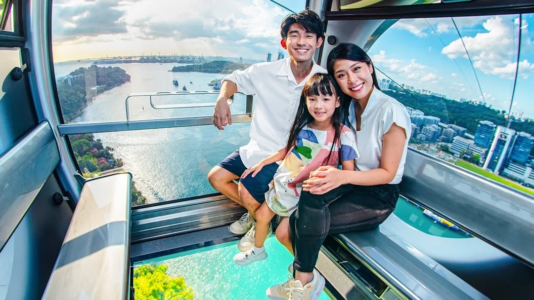 Family enjoying the view from the Sky Orb ride over a scenic waterfront.