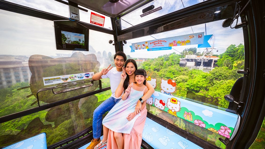 Tourists in Singapore Cable Car with city view, Hello Kitty theme, heading to S.E.A Aquarium.