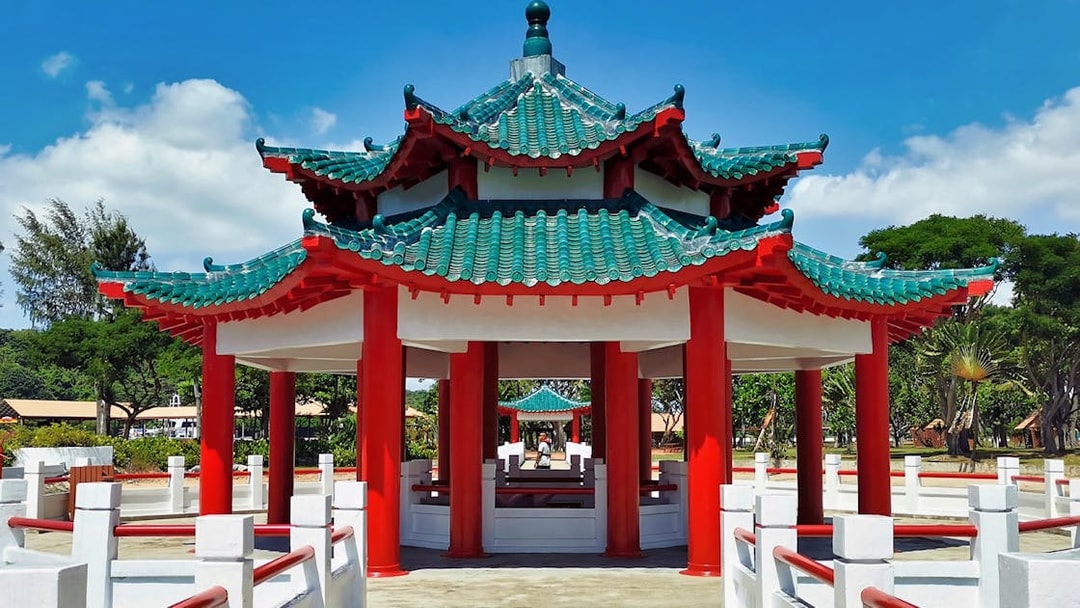 Pagoda on Kusu Island, Singapore, with red pillars and green tiled roof.