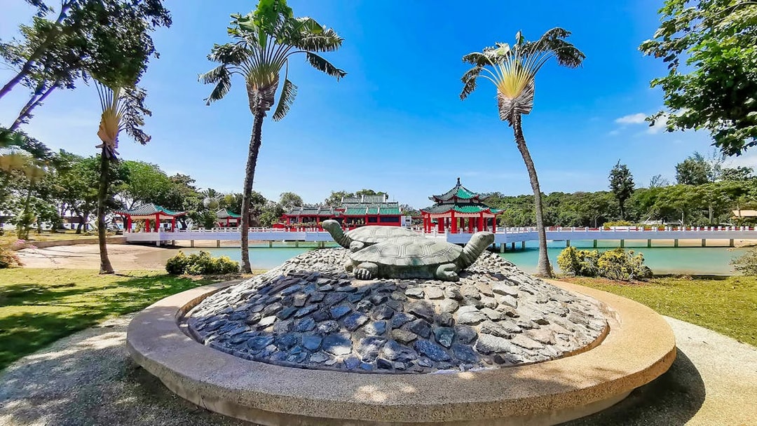 Kusu Island turtle statue with Chinese temple in background, Singapore.