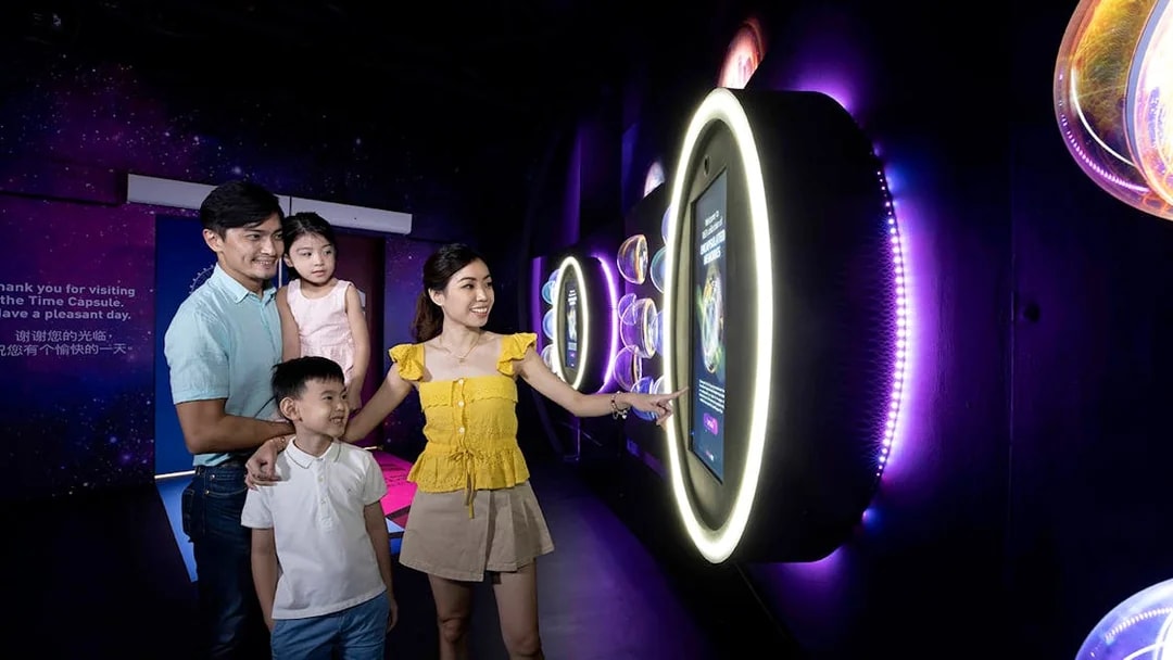 Family exploring interactive exhibit inside the Time Capsule, Singapore.