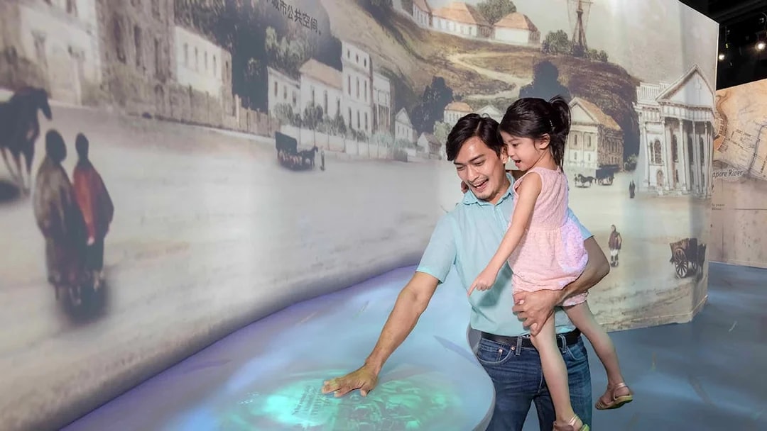 Family exploring interactive exhibit inside the Time Capsule, Singapore.