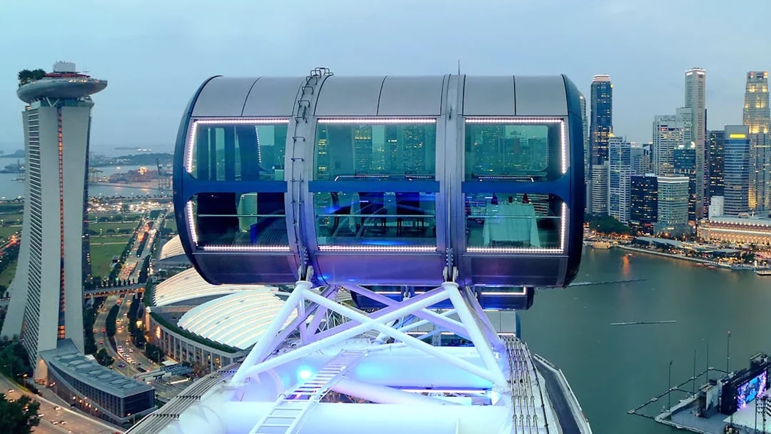 Singapore Flyer cabin illuminated for New Year's Eve, overlooking Marina Bay skyline.
