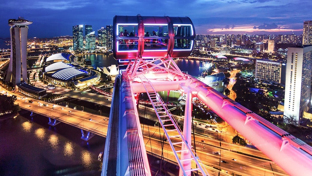 Singapore Flyer cabin illuminated for New Year's Eve, overlooking city skyline.