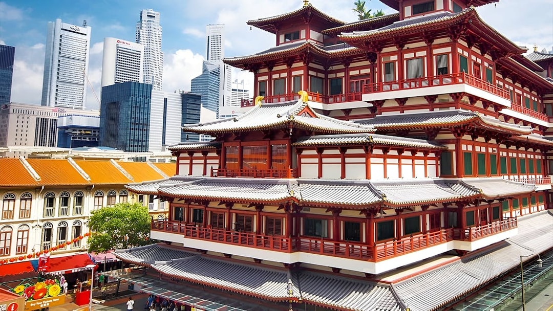 Buddha Tooth Relic Temple in Chinatown, Singapore with city skyline in the background.