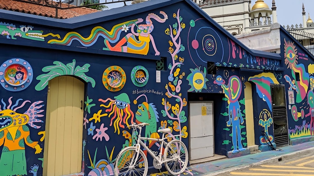 Colorful street art mural in Kampong Gelam, Singapore, featuring vibrant characters and patterns.