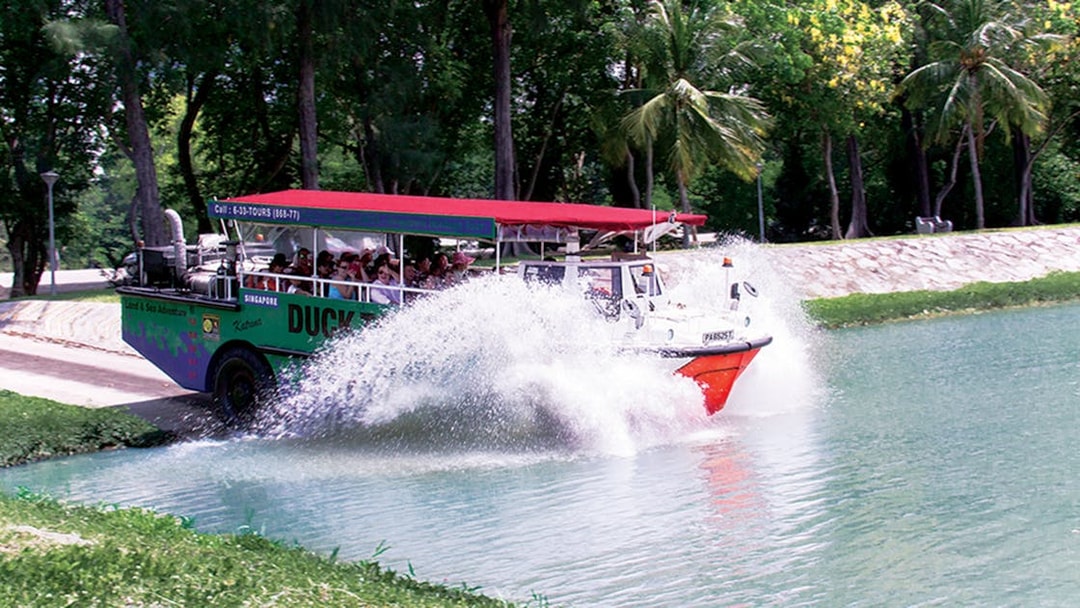 Amphibious vehicle splashing into water during DUCKtours Singapore.