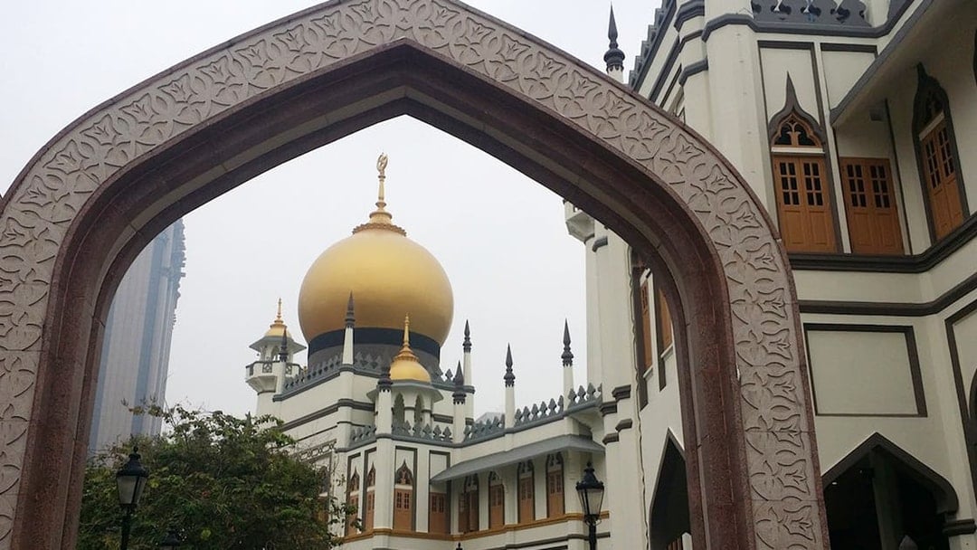 Sultan Mosque's golden dome framed by an arch in Singapore.