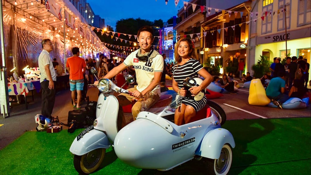 Couple on vintage Vespa sidecar during Singapore night tour.