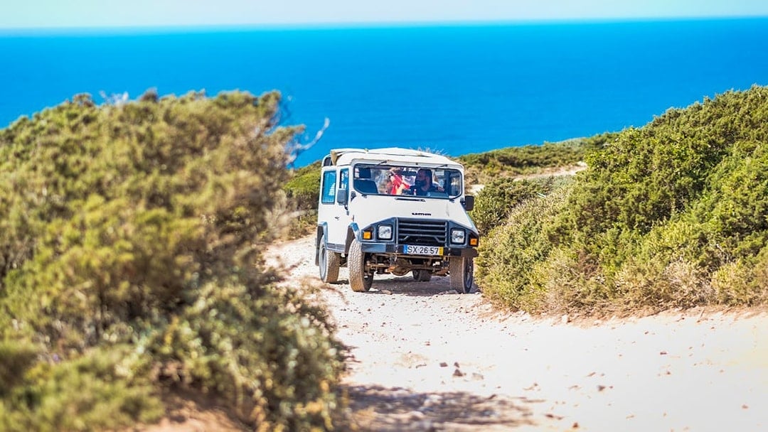 Jeep driving on a coastal trail during a guided safari tour in Sintra, Portugal.