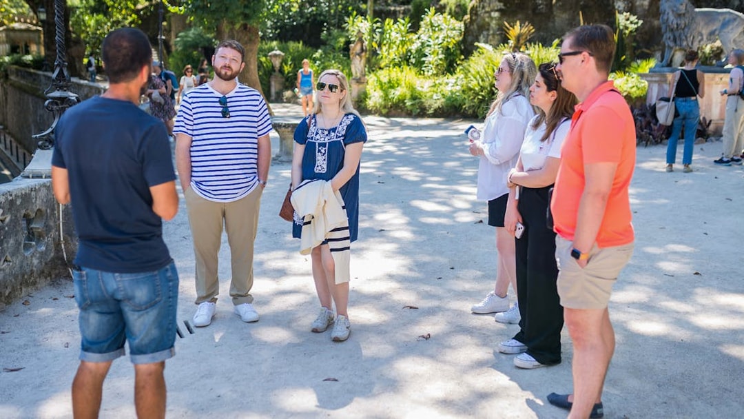 Group listening to guide during Sintra Jeep Safari tour, surrounded by lush greenery.